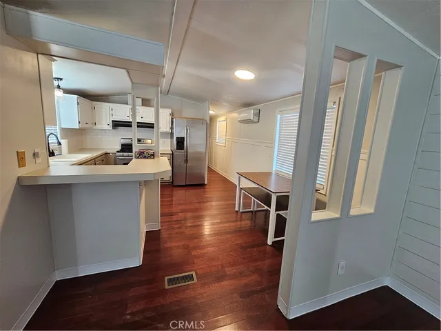a kitchen with stainless steel appliances a sink a stove a refrigerator and cabinets