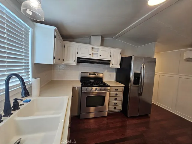 a kitchen with a stove a refrigerator and a sink