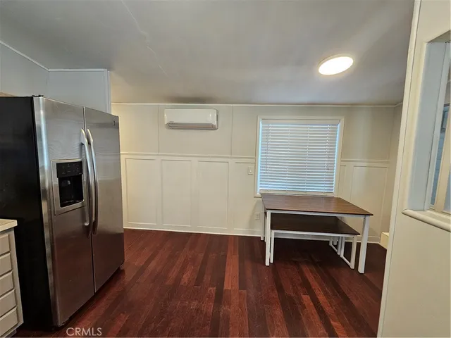 a view of a livingroom with wooden floor and electronic appliances