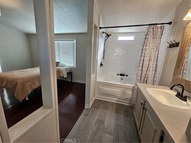 a bathroom with a tub sink and mirror