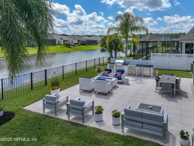 a view of a patio with couches table and chairs with potted plants and big yard