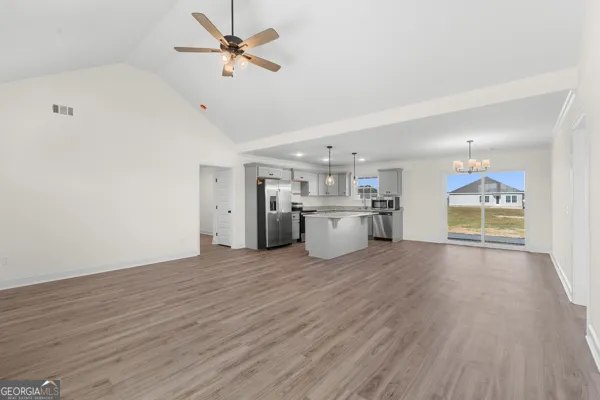 a view of a kitchen with a sink a ceiling fan and wooden floor