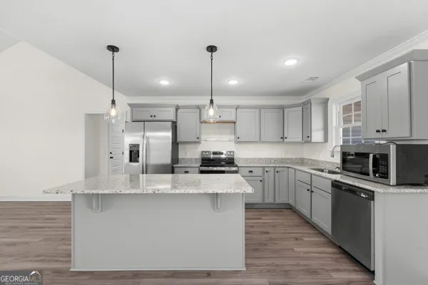 a kitchen with stainless steel appliances kitchen island granite countertop a stove a sink and a refrigerator