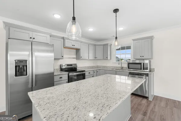 a kitchen with stainless steel appliances granite countertop a sink refrigerator and microwave