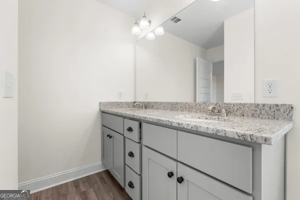 a bathroom with a granite countertop sink and a mirror