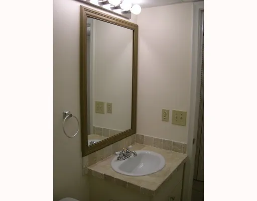 a bathroom with a sink and mirror with toilet