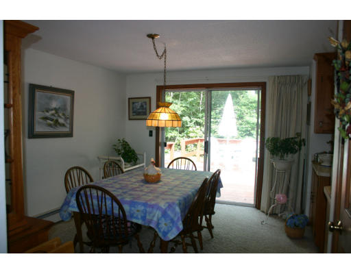 112 Skunknet Road Barnstable, MA 02632 - Photo 2 of 19 a dining room with furniture a chandelier and window