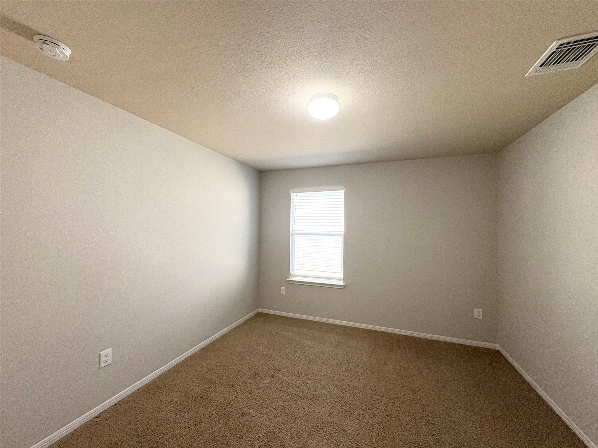 11708 Cambrian Road Manor, TX 78653 - Photo 21 of 31 An inviting room awaits with neutral walls and soft carpeting, ready for personalization.