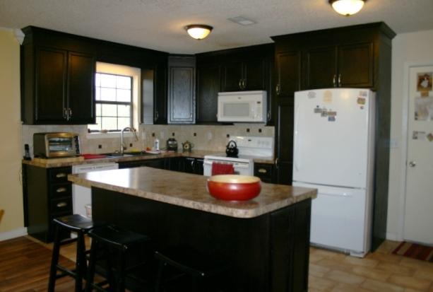 6540 Possum Ridge Road Crestview, FL 32539 - Photo 4 of 23 a kitchen with a sink a refrigerator and cabinets