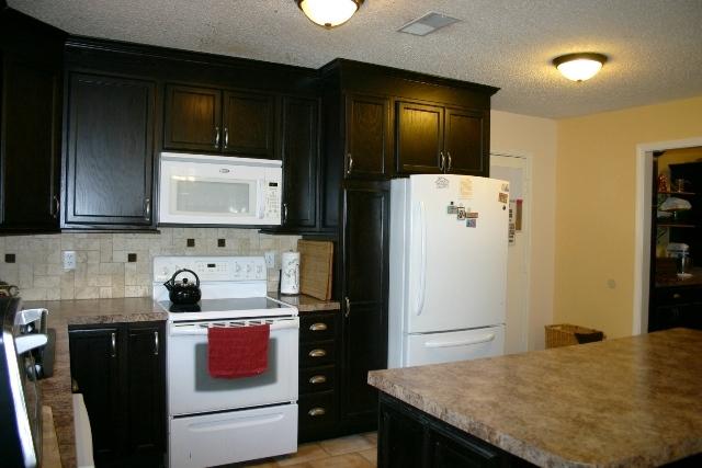 6540 Possum Ridge Road Crestview, FL 32539 - Photo 7 of 23 a kitchen with a refrigerator and a stove top oven