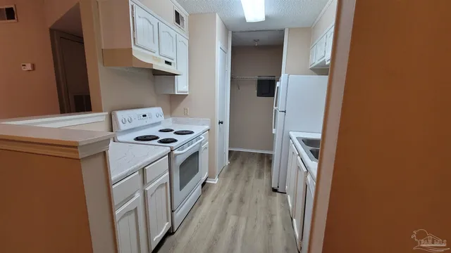 a kitchen with a refrigerator a stove and a cabinets