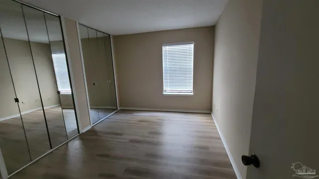 an empty room with wooden floor and sliding door