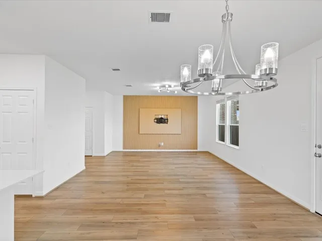 a view of a room with wooden floor and chandelier