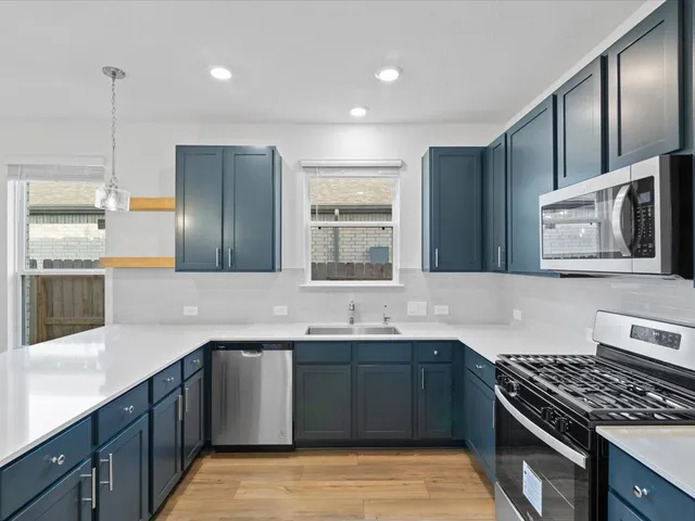 a kitchen with stainless steel appliances granite countertop a sink stove and refrigerator
