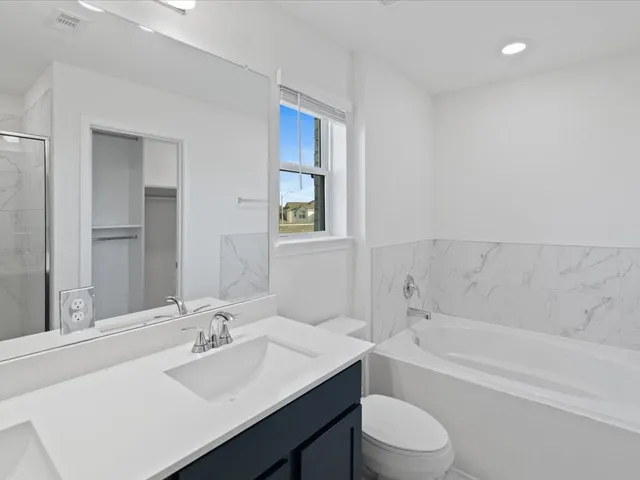 a bathroom with a granite countertop sink toilet and bathtub