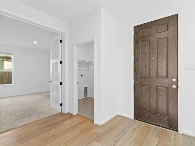 an empty room with wooden floor and closet area