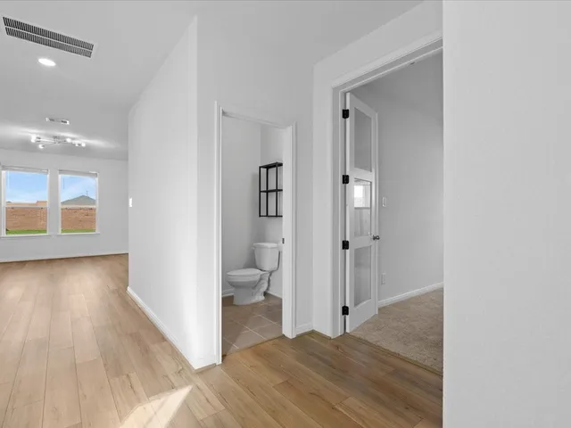a view of a room with wooden floor and a bathroom