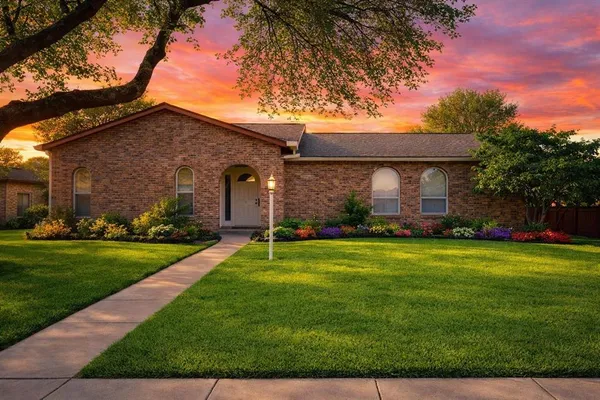 a front view of a house with a yard and trees