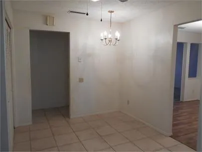 an empty room with chandelier fan