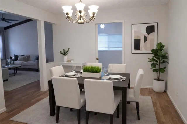 a view of a dining room with furniture wooden floor and a chandelier
