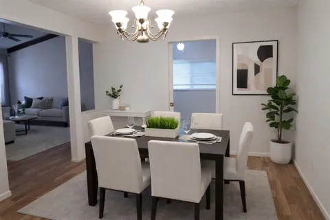 a view of a dining room with furniture wooden floor and a chandelier