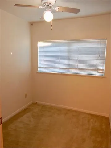 a view of a small space with wooden floor and a window