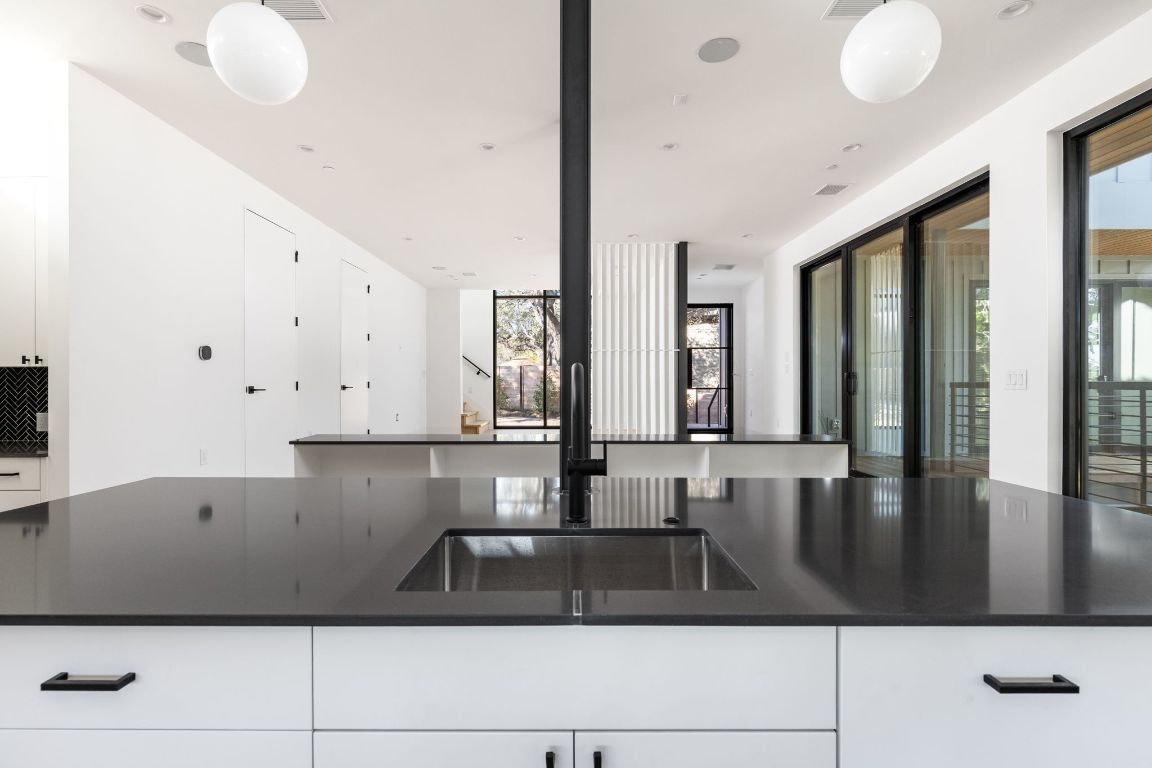 1603 Chelsea Lane, Unit 1 Austin, TX 78704 - Photo 12 of 40 Kitchen featuring white cabinetry, dark stone counters, and pendant lighting