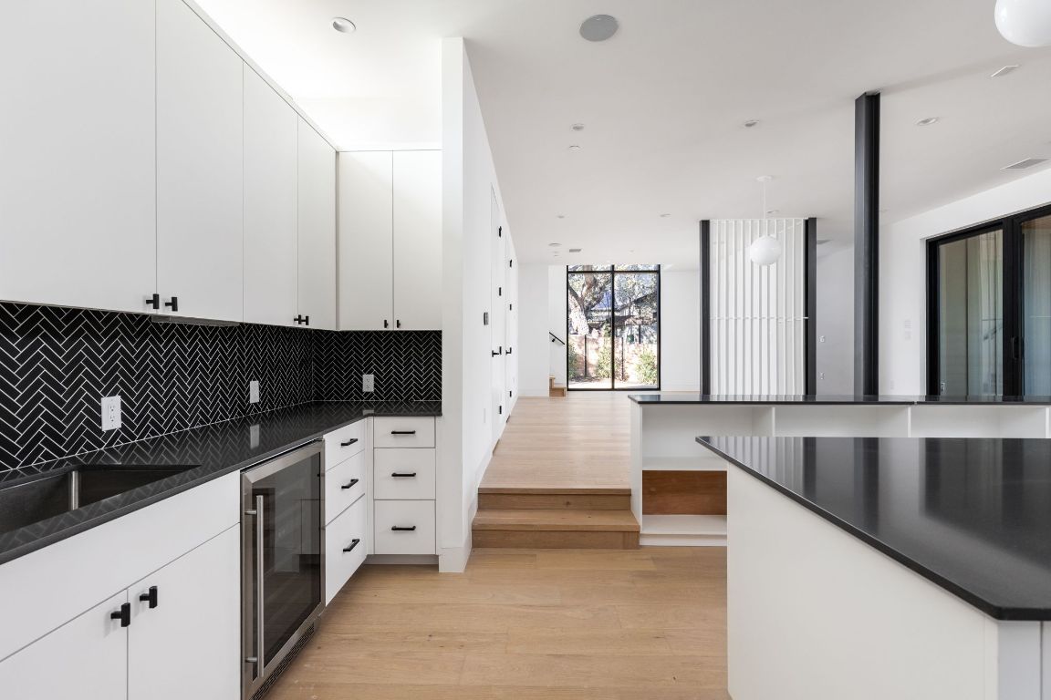 1603 Chelsea Lane, Unit 1 Austin, TX 78704 - Photo 13 of 40 Kitchen featuring light wood finished floors, white cabinetry, tasteful backsplash, and wine cooler
