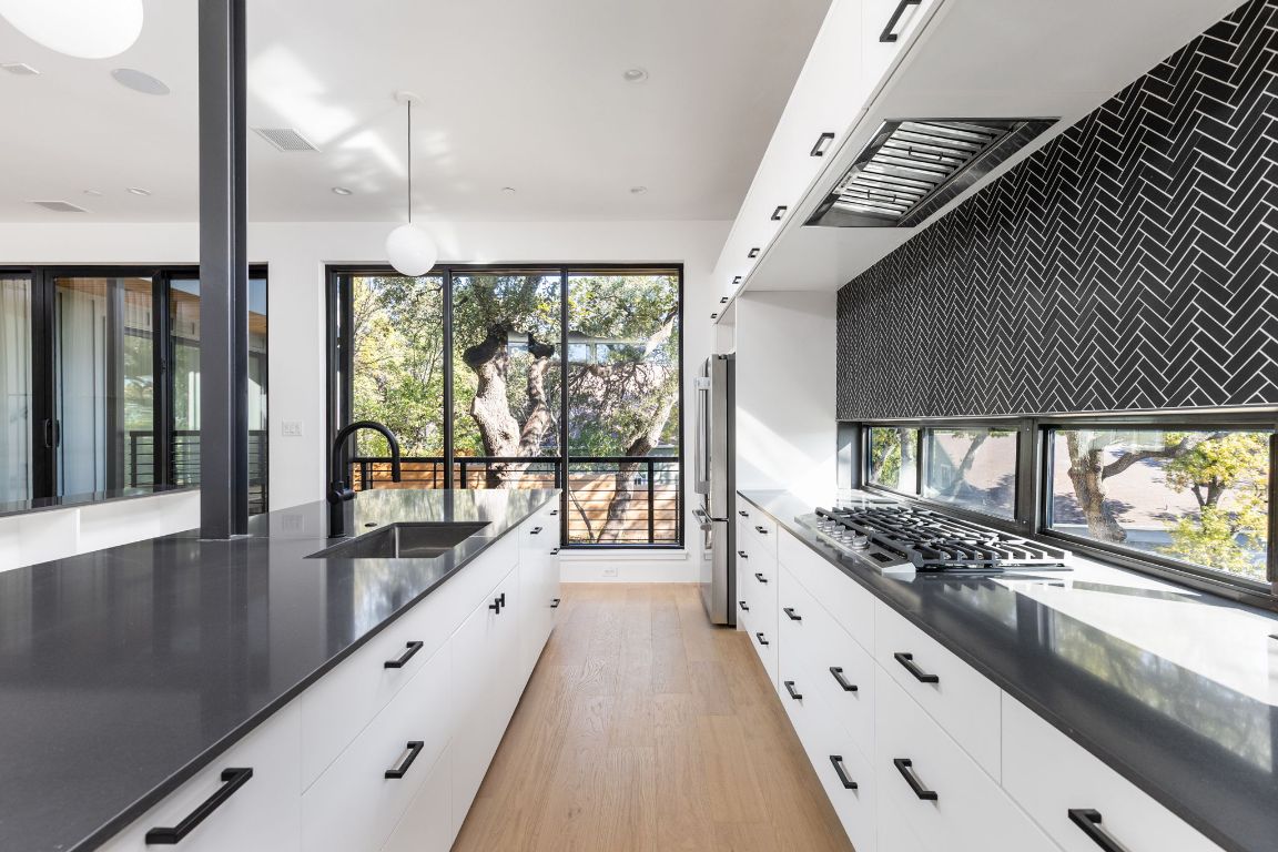 1603 Chelsea Lane, Unit 1 Austin, TX 78704 - Photo 14 of 40 Kitchen with white cabinetry, plenty of natural light, light wood-style flooring, and modern cabinets