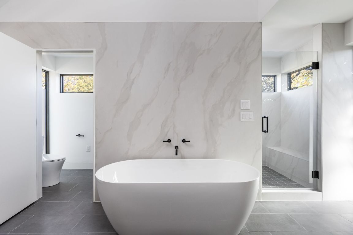 1603 Chelsea Lane, Unit 1 Austin, TX 78704 - Photo 19 of 40 Bathroom with healthy amount of natural light, a marble finish shower, a freestanding tub, and dark tile patterned flooring