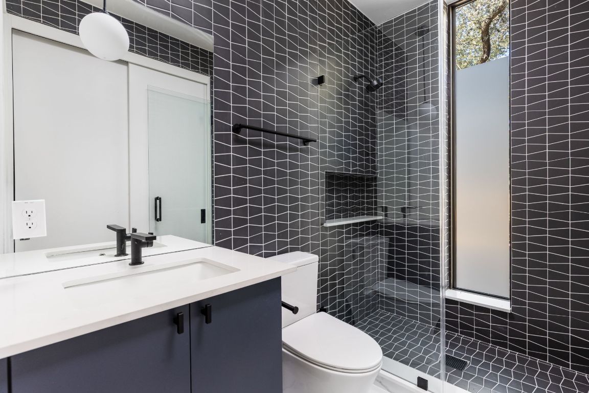 1603 Chelsea Lane, Unit 1 Austin, TX 78704 - Photo 23 of 40 Bathroom featuring vanity, tile walls, and a tile shower
