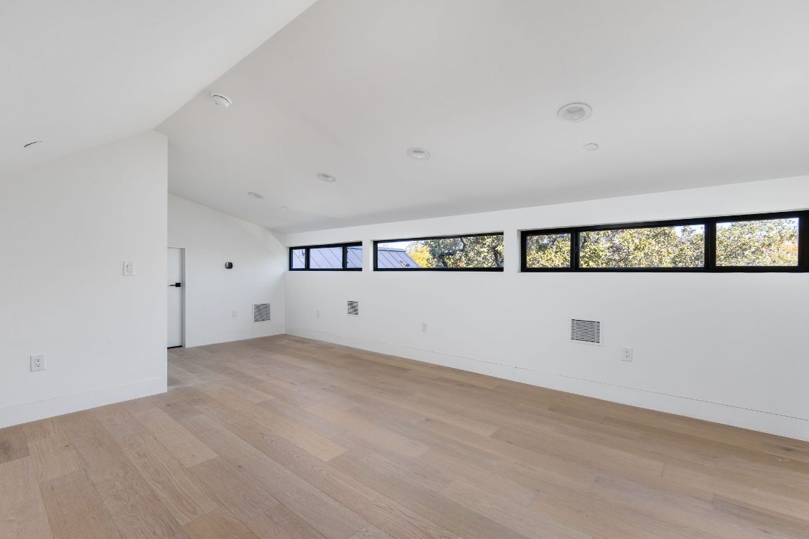 1603 Chelsea Lane, Unit 1 Austin, TX 78704 - Photo 32 of 40 Empty room with light wood-type flooring and lofted ceiling