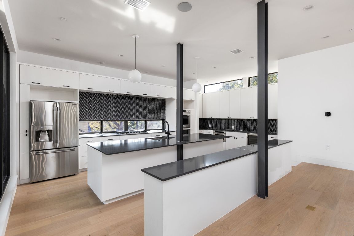 1603 Chelsea Lane, Unit 1 Austin, TX 78704 - Photo 6 of 40 Kitchen with healthy amount of natural light, stainless steel appliances, white cabinetry, light wood-style floors, and recessed lighting