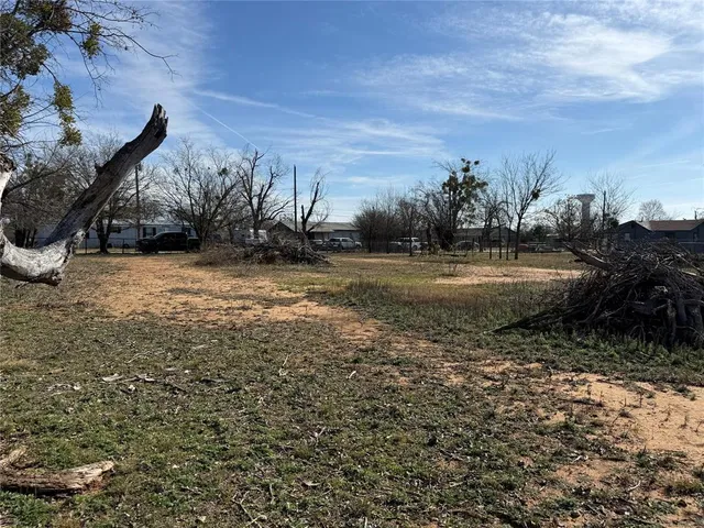 a view of dirt yard with wooden fence