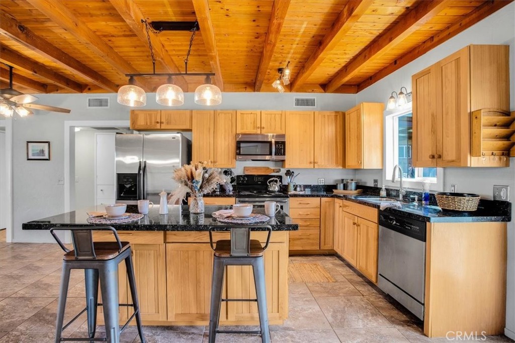 9384 Piedras Trail Morongo Valley, CA 92256 - Photo 14 of 75 a kitchen with stainless steel appliances granite countertop a sink and cabinets
