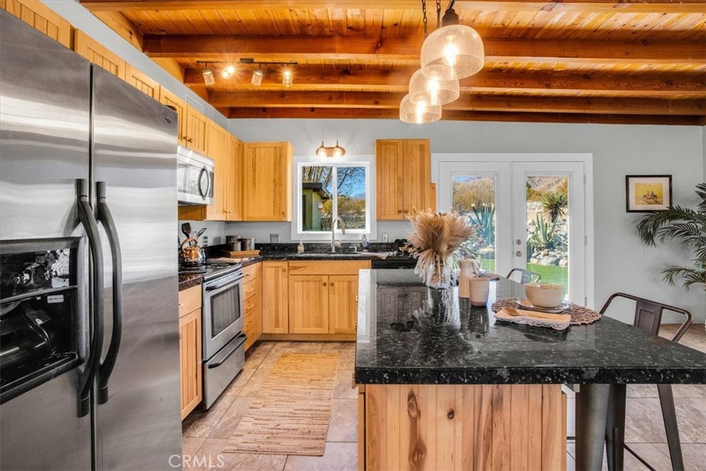 9384 Piedras Trail Morongo Valley, CA 92256 - Photo 15 of 75 a kitchen with stainless steel appliances granite countertop a sink window and cabinets