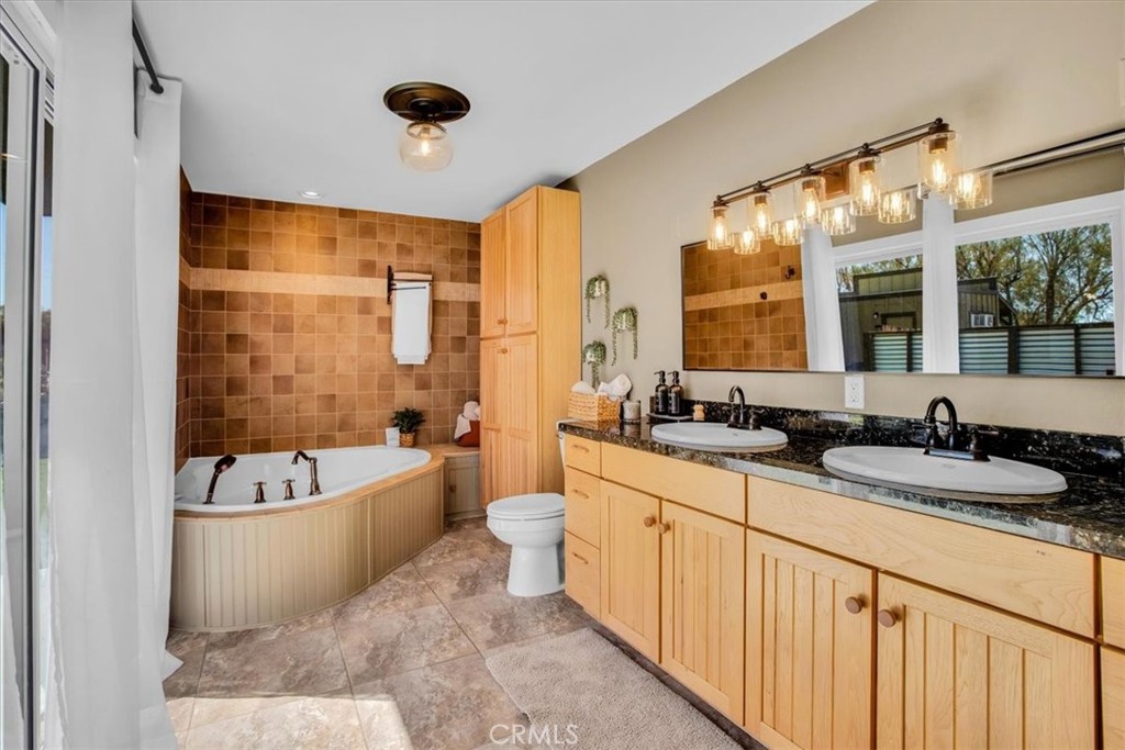9384 Piedras Trail Morongo Valley, CA 92256 - Photo 23 of 75 a bathroom with a double vanity sink a mirror a bathtub and shower