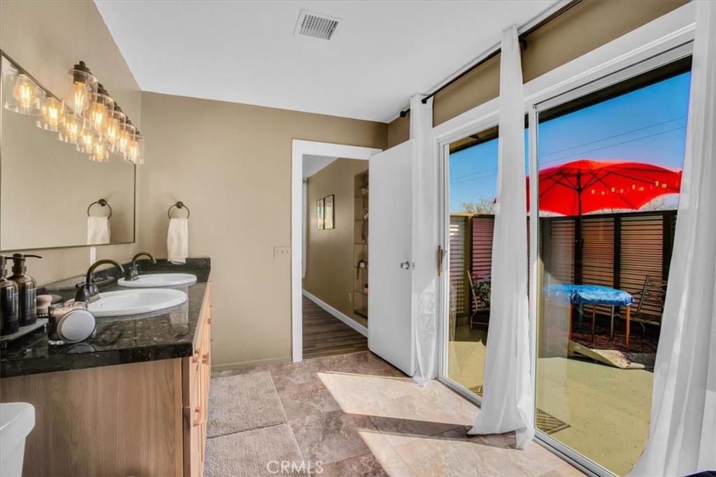 9384 Piedras Trail Morongo Valley, CA 92256 - Photo 24 of 75 a bathroom with double vanity and a shower
