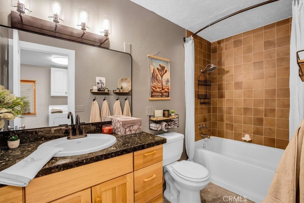 9384 Piedras Trail Morongo Valley, CA 92256 - Photo 27 of 75 a bathroom with a granite countertop sink a toilet a mirror a lamp a vanity and bathtub
