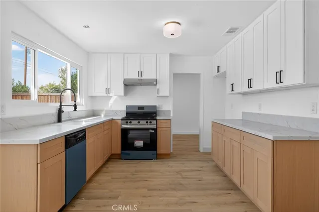 a kitchen with stainless steel appliances granite countertop a stove a sink and a refrigerator