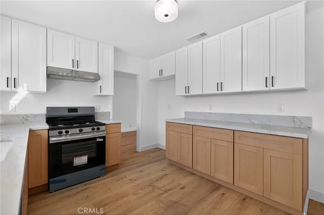 a kitchen with granite countertop white cabinets and stainless steel appliances