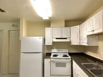 a kitchen with a stove a refrigerator and a sink