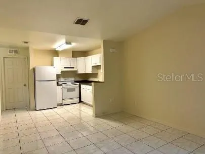 a kitchen with a refrigerator a stove top oven and a counter top space