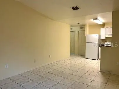 a view of a kitchen with a refrigerator and a stove top oven