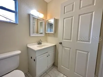 a bathroom with a granite countertop toilet sink and mirror