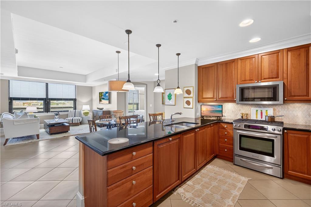 9115 Strada Place, Unit 5504 Naples, FL 34108 - Photo 6 of 22 a kitchen with stainless steel appliances granite countertop a sink a stove top oven a counter space cabinets and appliances
