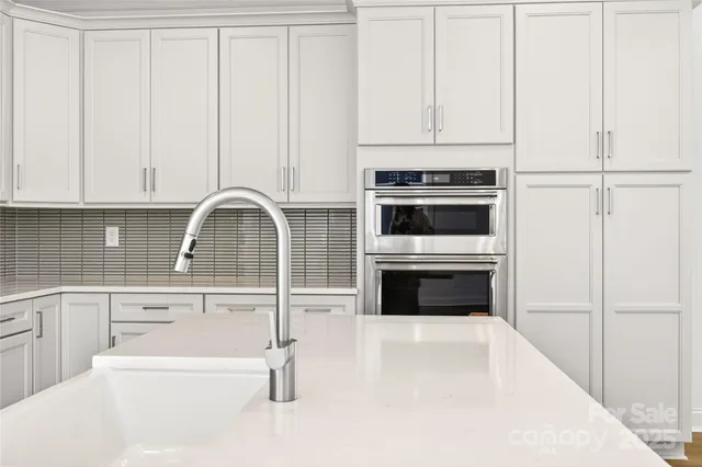 a kitchen with granite countertop white cabinets and white appliances