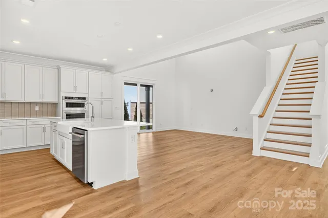 a kitchen with cabinets and wooden floor
