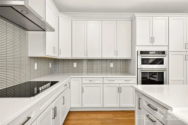 a kitchen with white cabinets and white appliances
