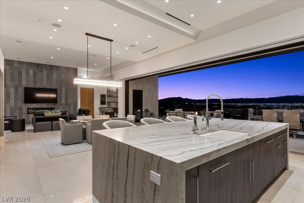 657 Ridgestone Rim Court Henderson, NV 89012 - Photo 97 of 97 An expansive open floor plan integrates a marble kitchen island with pocketing doors to panoramic views.